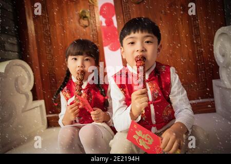 Die netten Jungen und Mädchen essen Eiszucker-Kürbis Stockfoto