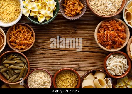 Set von verschiedenen Arten von Pasta in einer Schüssel auf Ein Holzhintergrund mit Kopierraum Stockfoto