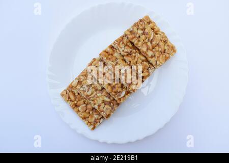 Selektiver Fokus Nahaufnahme von mungfali gajak oder Erdnuss Chkki eine indische traditionelle beliebte Süßigkeit aus Sesamsamen und Jaggery. Berühmte Sankranti f Stockfoto