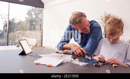 Enkel Mit Großvater Montage Elektronischer Komponenten, Um Roboter Zusammen Zu Bauen Zu Hause Stockfoto