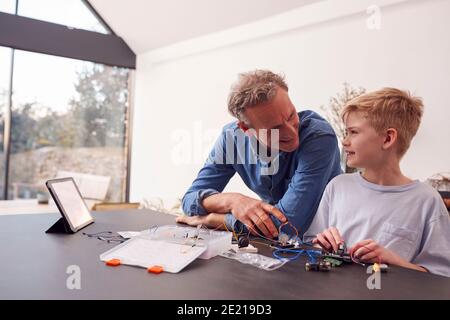 Enkel Mit Großvater Montage Elektronischer Komponenten, Um Roboter Zusammen Zu Bauen Zu Hause Stockfoto