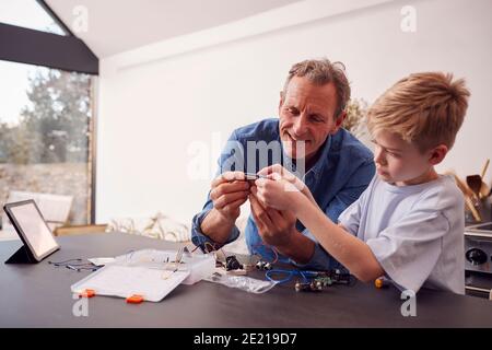 Enkel Mit Großvater Montage Elektronischer Komponenten, Um Roboter Zusammen Zu Bauen Zu Hause Stockfoto