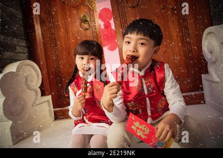 Die netten Jungen und Mädchen essen Eiszucker-Kürbis Stockfoto