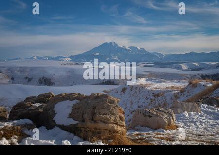 Mount Elbrus bedeckt mit Schnee im Winter und eine große Stein im Vordergrund Stockfoto