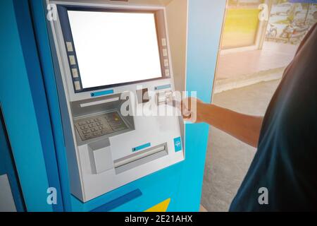 Ein Mann benutzt eine ATM-Karte Stockfoto