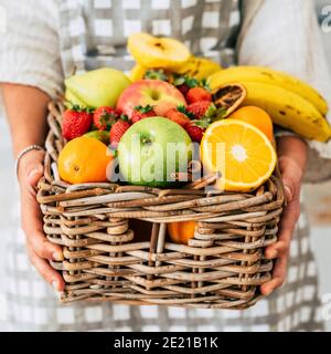 Gemischte frische Früchte auf Eimer Holz - Nahaufnahme Frau Hände halten Vitamin Obst Äpfel Orange Bananen - Konzept Der Speicher und vegetarisch gesunde Lebensmut Stockfoto