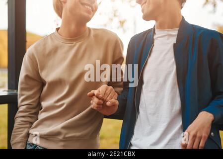 Zugeschnittenes Bild von liebenden Homosexuell paar im Freien. Zwei gutaussehende Männer mit romantischen Datum im Park und Hände halten. LGBT-Konzept. Stockfoto