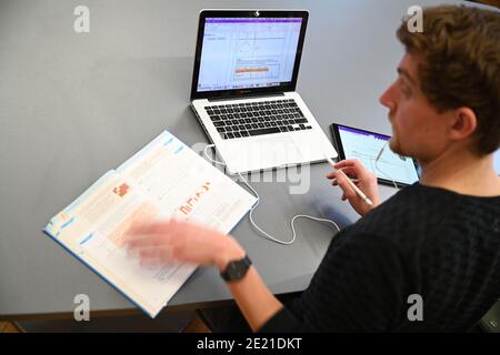 Ravensburg, Deutschland. Januar 2021. KORRIGIERT DEN NAMEN IM TITEL - Carlos Marschall, Mathe- und Spanischlehrer an der Spohnschule, unterrichtet auf einem Laptop in der Lehrerlounge. Für Fernunterricht verwendet er sowohl Laptop als auch iPad. Quelle: Felix Kästle/dpa/Alamy Live News Stockfoto