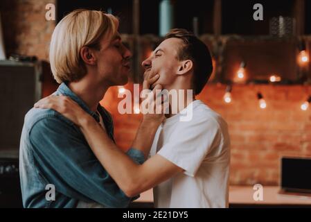 Loving Gay paar zu Hause. Zwei gutaussehende Männer umarmen und küssen auf Küche. LGBT-Konzept. Stockfoto