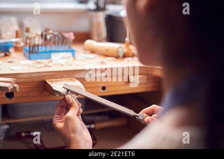 Nahaufnahme Einer Juwelierin, Die Am Ring Mit Datei Arbeitet In Studio Stockfoto