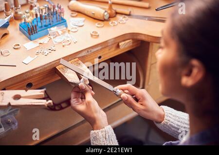 Nahaufnahme Einer Juwelierin, Die Am Ring Mit Datei Arbeitet In Studio Stockfoto