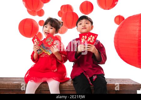 Glückliche Jungen und Mädchen mit roten Umschlägen Stockfoto