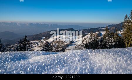 Verschneite Sicht auf Fraxern und das Rheintal. Winterlandschaft in den Bergen von Österreich, starker Kontrast mit Nebelmeer über dem Bodensee Stockfoto