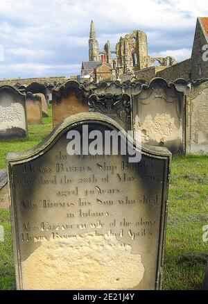 Grab von Henry BARRICK , bekannt Schiffsbauer (Henry & George Barrick Werft) in Whitby, North Yorkshire (Parish Church Friedhof, Whitby), wie es im Jahr 2005 war. Ihre Werft liegt an dem, was jetzt Dock End, Whitby . Der Grabstein, jetzt stark von Wind und Zeit erodiert, steht in der Nähe des Seiteneingangs des Friedhofs, mit WhitbyAbbey dahinter. Die Inschrift lautet "in Erinnerung an Henry Barrick , Schiffsbauer, der am 27. Mai 1797 im Alter von 40 Jahren starb. Auch Thomas sein Sohn, der in der Kindheit starb. Auch Elizabeth Ehefrau des oben genannten Henry Barrick (...... Unlesbar.....) April (Rest unreadabl Stockfoto