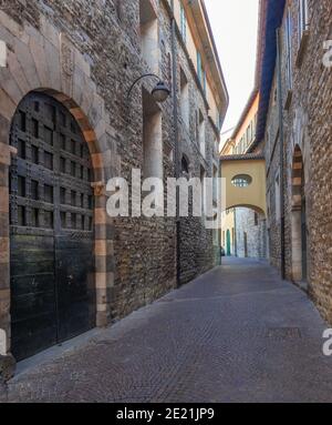 Blick entlang einer mittelalterlichen, dunklen und engen Gasse mit altem Stein houses.Como, Lombardei.Italien Stockfoto