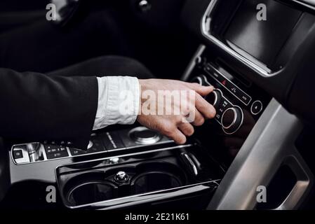 Nahaufnahme des männlichen Handdrehens der Klimaanlage. Transport- und Fahrzeugkonzept Stockfoto