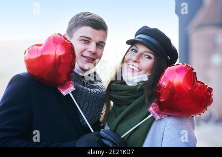 Glückliches Paar feiert Valentinstag in Masken während covid-19 Pandemie Stockfoto