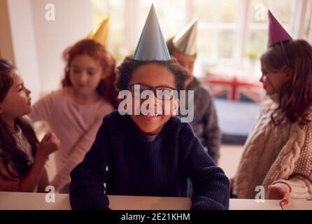 Portrait Of Children Feiert Geburtstag Mit Gruppe Von Freunden An Zu Hause Stockfoto