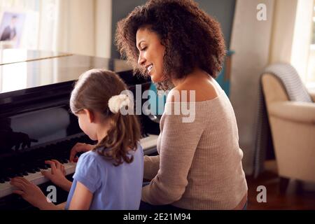 Junges Mädchen Lernen, Klavier Zu Spielen Mit Lektion Von Weiblich Lehrer Stockfoto