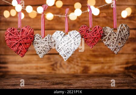Valentine Herzen hängen an einem Seil auf Holzhintergrund. Selektiver Fokus, Kopierbereich. Stockfoto