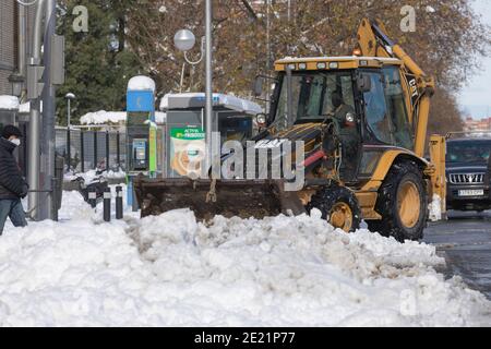 Madrid, Spanien - 10. Januar 2021: Ein Bagger entfernt Schnee mit seiner Schaufel, in der Ambulanz Zugang Bereich des Krankenhauses General Universitario, Grego Stockfoto