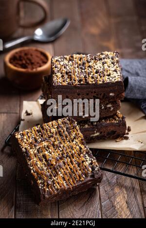 Dunkle Schokolade Brownies gekrönt mit Karamell und Nüsse auf einem Drahtgitter Stockfoto