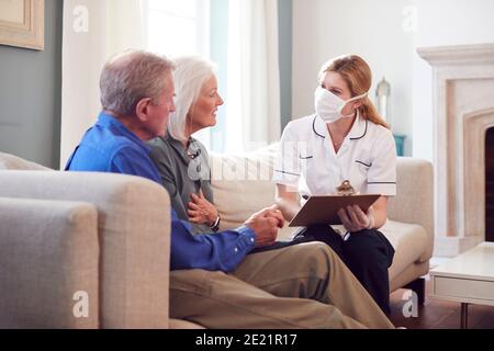 Weibliche Arzt Mit Maske Macht Nach Hause Besuch Zu Älteren Paar Zur Medizinischen Überprüfung Während Der Covid-19-Sperre Stockfoto