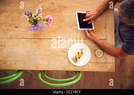 Overhead-Ansicht Von Reifen Mann Arbeiten Auf Digital Tablet In Café-Bar Stockfoto