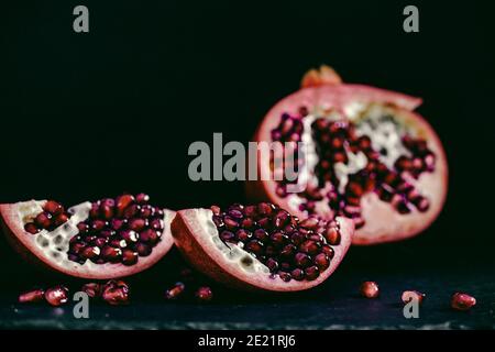 Granatapfel Stücke auf schwarzem Hintergrund Stockfoto