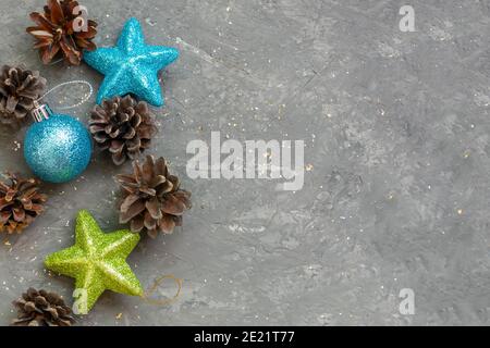 Tannenzapfen und Spielzeug für Weihnachtsbaum auf dunkelgrauem Beton Hintergrund. Kopierbereich, selektiver Fokus, Stimmung im neuen Jahr. Stockfoto