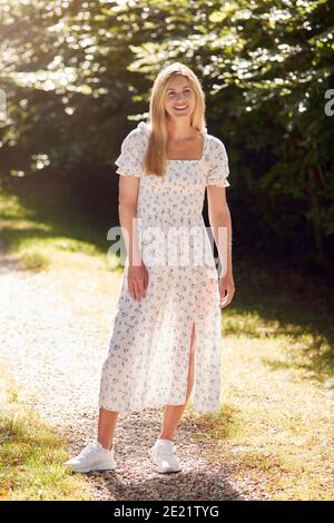 Full Length Portrait Der Lächelnden Frau Trägt Sommerkleid Zu Fuß Entlang Landweg Stockfoto