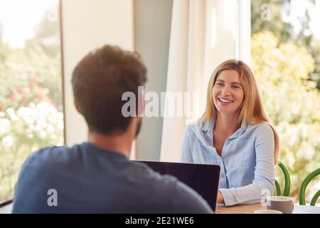 Paar Mit Laptop Sitzen Am Tisch Arbeiten Von Zu Hause Aus Zusammen Stockfoto