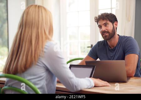 Paar Mit Laptop Sitzen Am Tisch Arbeiten Von Zu Hause Aus Zusammen Stockfoto