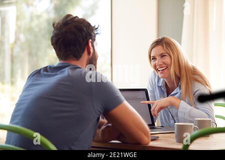 Paar Mit Laptop Sitzen Am Tisch Arbeiten Von Zu Hause Aus Zusammen Stockfoto