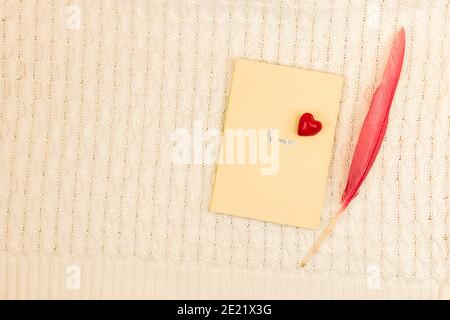 Valentinstag kreatives Konzept sein meine, Liebe Thema, Komposition mit Notizbuch, rotes Herz und farbige Feder Foto Stockfoto