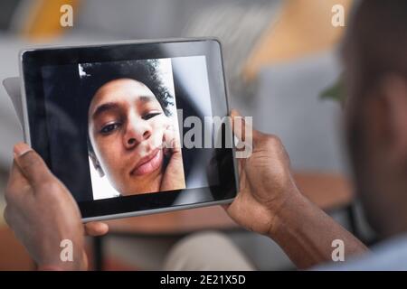 Unkenntlich afroamerikanischen Mann hält digitale Tablette mit Videoanruf Mit seinem Teenager-Sohn Stockfoto