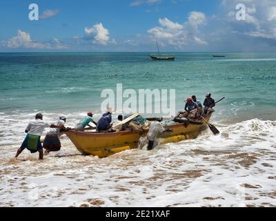 TANGALA, SRI LANKA - 15. März 2019: Asiatische Fischer schieben Holzboot auf dem Meer. Stockfoto