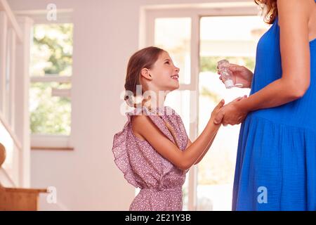 Mutter Und Tochter Verwenden Vor Dem Verlassen Des Hauses Ein Desinfektionsmittel Stockfoto