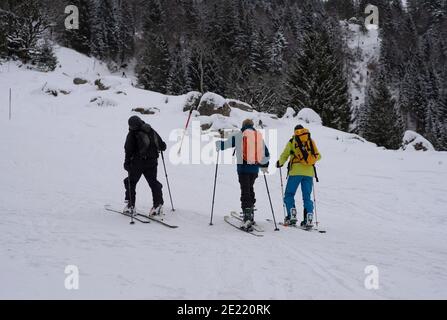 Eine dynamische Szene, in der eine Gruppe von Skifahrern während einer Skitour durch eine schneebedeckte Berglandschaft navigiert. Stockfoto