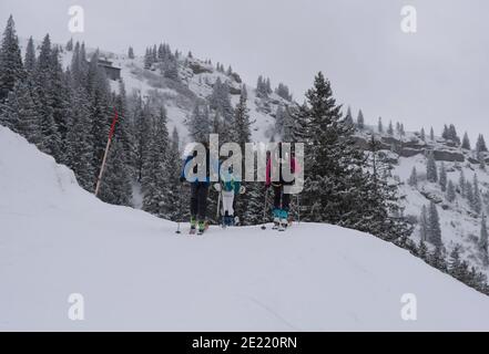 Eine dynamische Szene, in der eine Gruppe von Skifahrern während einer Skitour durch eine schneebedeckte Berglandschaft navigiert. Stockfoto