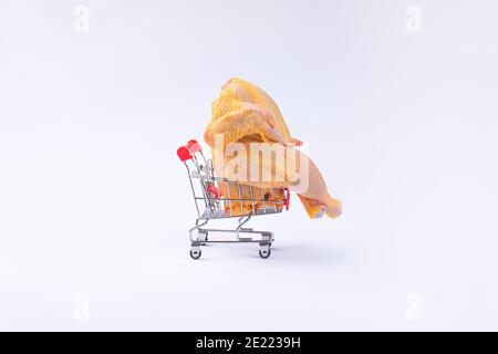 Ganze rohes Huhn in einem Supermarkt-Trolley.frisches ganzes Huhn auf einem schwarzen Kücheboard. Diät-Essen. Stockfoto