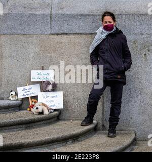 Alexanderplatz,Mitte, Berlin, Deutschland. Januar 2021. Ein einsames Schulmädchen protestiert vor dem Berliner Rathaus über die Schließung von Schulen während der Corona-Pandemiesperre. Eine Sammlung von weichen Spielzeug mit kleinen Bannern drücken ihre Gefühle, ich will zur Schule gehen, ich bin so gelangweilt, whre sind meine Freunde Stockfoto