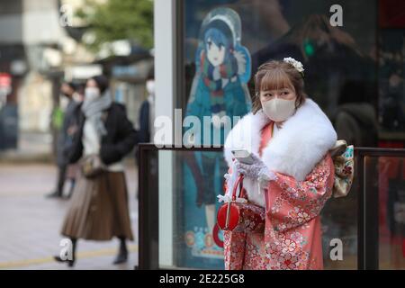 Eine Frau, die Kimono und Maske trägt, verbringt Zeit in Shibuya Crossing während des "Coming of Age"-Tages im Jahr Tokyo.Coming des Age Day und feiert diejenigen, die 20 Jahre alt geworden sind. Es ist Feiertag am zweiten Montag im Januar in Japan. Angesichts der steigenden COVID19-Infektionsrate in ganz Japan war der Coming of Age Day von 2021 jedoch nicht wie gewöhnlich. Die feierliche Zeremonie war nur online in den meisten Büros der Stadt in Japan. Im beliebten Ort Shibuya Crossing waren nur wenige Mädchen in schönen Kimono. Alle Menschen tragen Maske. Stockfoto