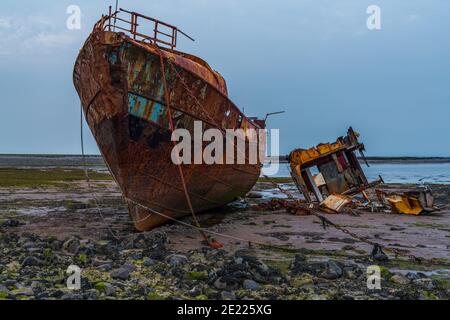 Ein rostiges Schiffswrack im Schlamm der Walney Kanal, von der Straße auf Roa Island, Cumbria, England, UK gesehen Stockfoto