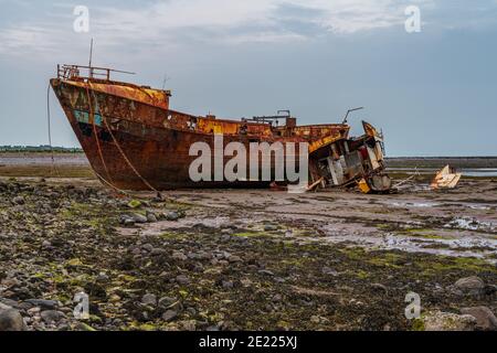 Ein rostiges Schiffswrack im Schlamm der Walney Kanal, von der Straße auf Roa Island, Cumbria, England, UK gesehen Stockfoto