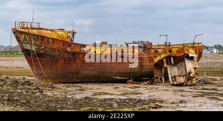 Ein rostiges Schiffswrack im Schlamm der Walney Kanal, von der Straße auf Roa Island, Cumbria, England, UK gesehen Stockfoto