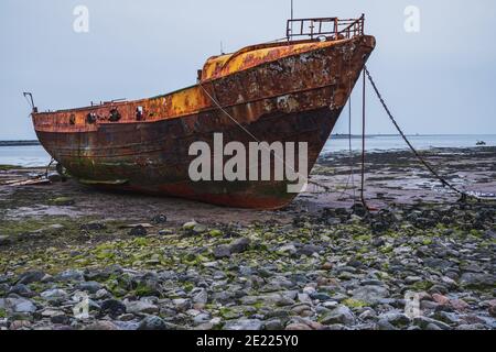 Ein rostiges Schiffswrack im Schlamm der Walney Kanal, von der Straße auf Roa Island, Cumbria, England, UK gesehen Stockfoto