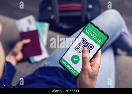 Geimpfte Person mit digitalen Gesundheitspass-App im Handy Für Reisen während der covid-19 Pandemie Stockfoto