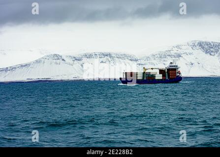 Schöne Aufnahme von einem Bord Schiff in blauem Meer voll Von Wellen vor einem verschneiten Berg in Island Stockfoto