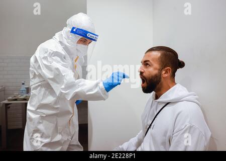 Köln, Nordrhein-Westfalen, Deutschland - Covid-Schnelltest im Medicare-Testzentrum, Rachenabstrich auf Wattestäbchen - Modell freigegeben - Stockfoto